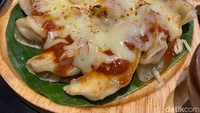 Cheese Melt Pizza Gyoza seharga Rp 88.000. Satu porsinya berisikan 12 buah gyoza dengan isian ayam yang padat, kemudian disajikan melingkar seperti pizza dan diberikan topping saus tomat serta keju mozzarella. menu ini cocok disantap 3-4 orang. Foto: detikFood / Yenny Mustika Sari