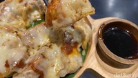 Pizza gyoza ini disajikan dengan shoyu dan acar jahe. Saat keju mozzarella masih mulur dan hangat, gyoza ini langsung kami santap. Foto: detikFood / Yenny Mustika Sari