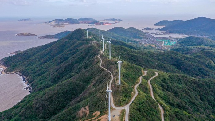 Melihat Pembangkit Listrik Tenaga Angin di Pegunungan China ZHOUSHAN, CHINA - NOVEMBER 1, 2022 - An aerial photo shows wind turbines turning under the action of sea breeze at Qushandao Wind Farm in Zhoushan City, Zhejiang Province, China, Nov 1, 2022. (Photo credit should read CFOTO/Future Publishing via Getty Images)