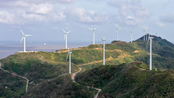 Melihat Pembangkit Listrik Tenaga Angin di Pegunungan China ZHOUSHAN, CHINA - NOVEMBER 1, 2022 - An aerial photo shows wind turbines turning under the action of sea breeze at Qushandao Wind Farm in Zhoushan City, Zhejiang Province, China, Nov 1, 2022. (Photo credit should read CFOTO/Future Publishing via Getty Images)