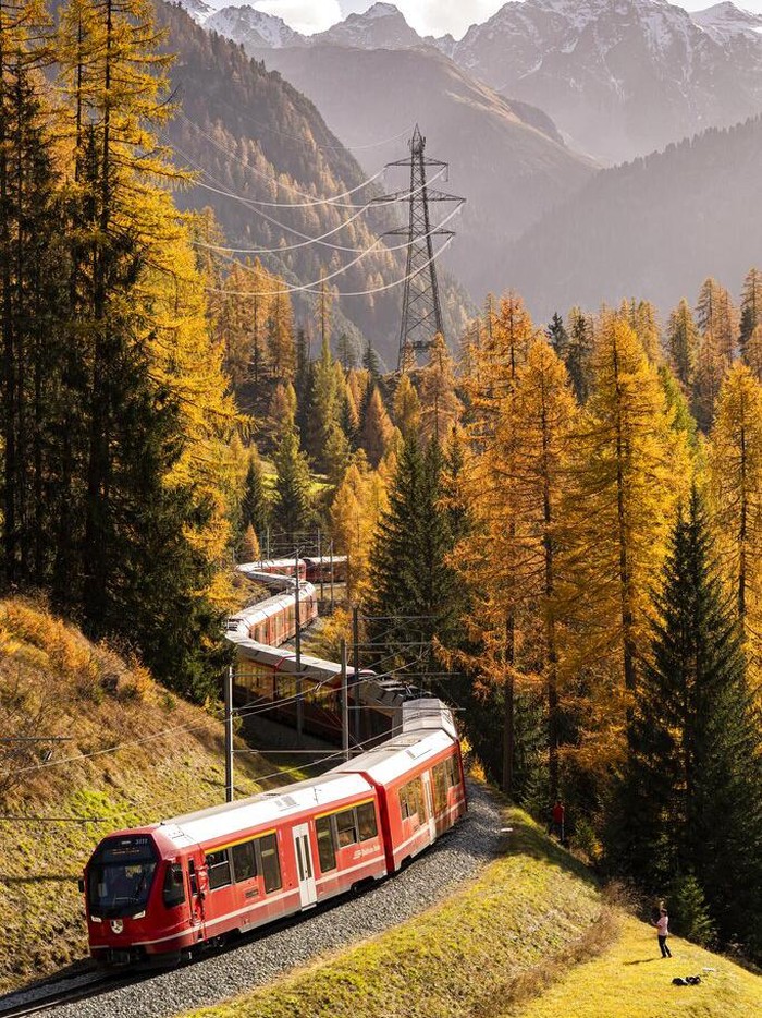 Potret Kereta Terpanjang di Dunia Meliuk-liuk di Pegunungan Swiss A train of the Rhaetian Railway (RHB) is on its way to set a world record for longest passenger train, on Saturday, October 29, 2022, in Berguen, Switzerland. The 1.91 kilometer long train is on a journey on the UNESCO world heritage track from Preda to Alvaneu. The train consists of 100 waggons. The old world record of 1732,9 meters dates back to 1991. (Yanik Buerkli/Keystone via AP)