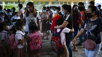Seorang siswa memeluk penjemputnya di sebuah sekolah umum di Kota Quezon. Anak-anak nampak sukacita dengan dimulainya kembali belajar tatap muka di kelas.