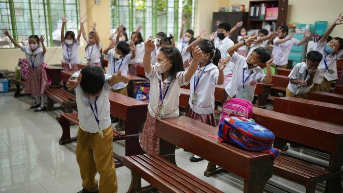 A teacher arranges chairs before the start of class at a public school in Quezon City, Philippines on Wednesday, Nov. 2, 2022. Millions of students trooped back to public schools across the Philippines on Wednesday as the government enforced the mandatory resumption of in-person classes after more than two years of coronavirus pandemic lockdowns. (AP Photo/Aaron Favila)