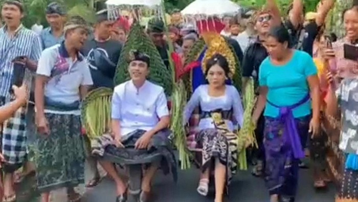 Tangkapan layar kedua mempelai pengantin naik gerobak saat prosesi ngidih di Banjar Dinas Kebung Kauh, Desa Telaga Tawang, Kecamatan Sidemen, Kabupaten Karangasem, Bali. (Istimewa)