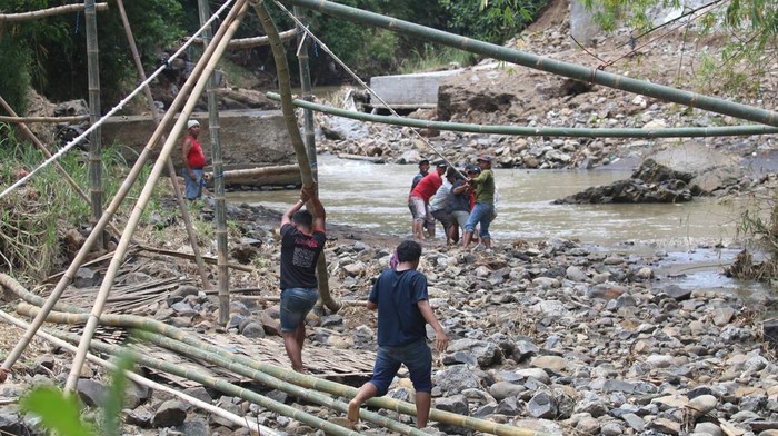 Warga bergotong royong membuat jembatan bambu di Desa Ngadi, Kediri, Jawa Timur, Rabu (2/11/2022). Jembatan bambu setinggi 40 meter penghubung Kediri dengan Tulungagung tersebut dibuat kembali setelah sebelumnya rusak terbawa arus sungai. ANTARA FOTO/Prasetia Fauzani/rwa.