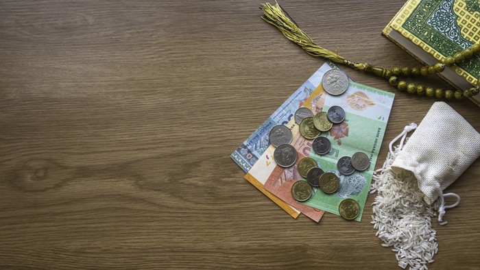 Concept of zakat in Islam religion. Top view of money, rice, prayer beads beads and Quran on wooden background with copy space.