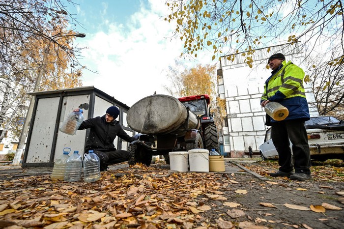 STEPNOHIRSK, UKRAINE - NOVEMBER 2, 2022 - A cat sits by a bucket of water that is being delivered by a farmer to local residents as the urban-type settlement close to the front line has had no water supply for eight months due to the shelling by Russian troops, Stepnohirsk, Zaporizhzhia Region, southeastern Ukraine. (Photo credit should read Dmytro Smolienko / Ukrinform/Future Publishing via Getty Images)