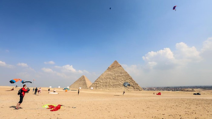 GIZA, EGYPT - NOVEMBER 02: Skydivers fly over the pyramids of Giza during the skydiving festival with the participation of more than a thousand skydivers from 20 states on November 02, 2022, in Giza, Egypt. (Photo by Mohamed Abdel Hamid/Anadolu Agency via Getty Images)
