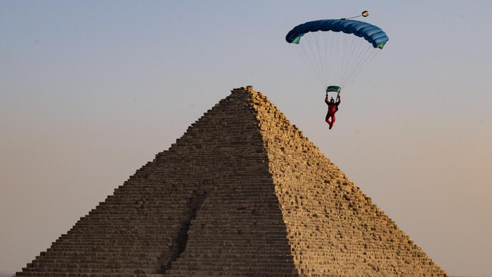 GIZA, EGYPT - NOVEMBER 02: Skydivers fly over the pyramids of Giza during the skydiving festival with the participation of more than a thousand skydivers from 20 states on November 02, 2022, in Giza, Egypt. (Photo by Mohamed Abdel Hamid/Anadolu Agency via Getty Images)