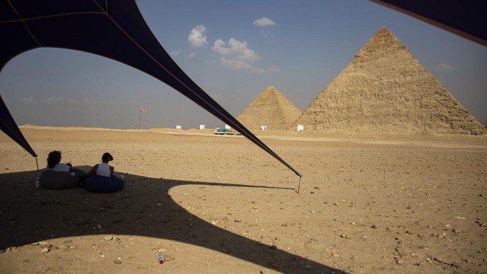 Aksi Penerjun Payung Meluncur di Atas Piramida Mesir GIZA, EGYPT - NOVEMBER 02: Skydivers fly over the pyramids of Giza during the skydiving festival with the participation of more than a thousand skydivers from 20 states on November 02, 2022, in Giza, Egypt. (Photo by Mohamed Abdel Hamid/Anadolu Agency via Getty Images)