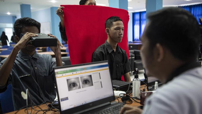Petugas melakukan perekaman data biometrik mata saat pembuatan KTP elektronik bagi siswa di SMK Negeri 2 Palembang, Sumatera Selatan, Kamis (3/11/2022). Dinas Kependudukan dan Catatan Sipil (Disdukcapil) Kota Palembang melakukan perekaman KTP elektronik bagi siswa SMK dan sederajat dengan mendatangi langsung sejumlah sekolah untuk mempercepat dan memudahkan siswa yang telah berusia 17 tahun mendapatkan KTP elektronik. ANTARA FOTO/Nova Wahyudi/wsj.