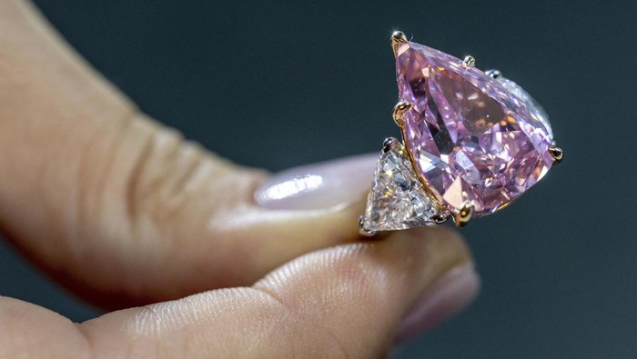 Batu Permata Fortune Pink Akan Dilelang, Berminat? A model holds a 18,18 carat pink diamond called