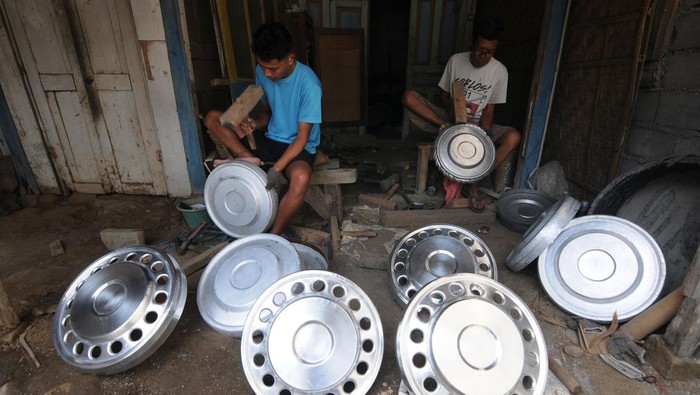 KERAJINAN TUTUP RODA EKSPOR Perajin menempa bahan saat membuat kerajinan tutup roda pelek atau