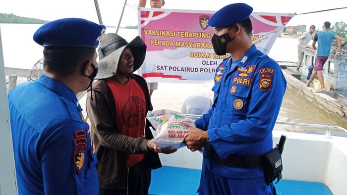 Anggota Polres Rohil saat vaksinasi dan pemberian bantuan (Foto: Istimewa)