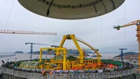 Alat berat sedang memasang kubah untuk gedung reaktor unit 1.