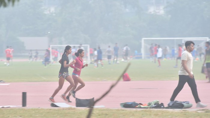 NEW DELHI, INDIA - NOVEMBER 3: Athletes train at Jawaharlal Nehru Stadium on a smoggy morning  on November 3, 2022 in New Delhi, India. The thick toxic smog blanketed the Jawaharlal Nehru Stadium even as the athletes went about their training there. Some jogged and some sprinted on the track even as the air quality dipped to severe levels in the national capital on Thursday (AQI of 449 at JLN stadium). Many stopped after a brief run while some were seen coughing.(Photo by Raj K Raj/Hindustan Times via Getty Images)