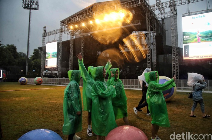 Sejumlah pengunjung menikmati konser Joyland Festival 2022 saat hujan deras di kawasan lapangan Soft Ball Gelora Bung Karno, Jumat (4/11/2022).  Walaupun hujan deras, penonton tetap antusias menonton.