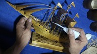 Perajin penyandang disabilitas Moch Sobirin merangkai miniatur perahu di Desa Pranggang, Kediri, Jawa Timur, Jumat (4/11/2022). Miniatur ini terbuat dari bahan baku bambu.