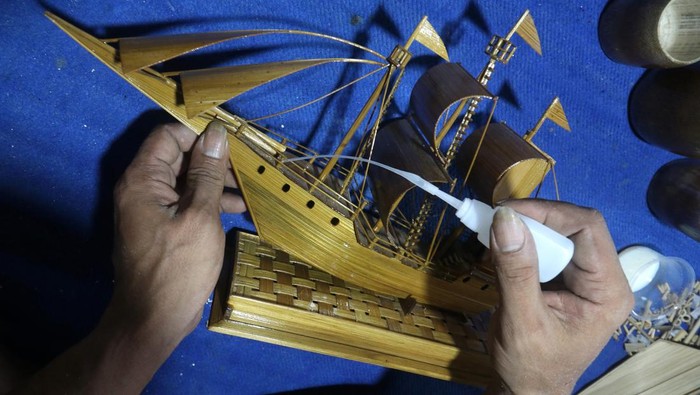 Perajin penyandang disabilitas Moch Sobirin memasang kaca pelindung pada miniatur perahu buatannya di Desa Pranggang, Kediri, Jawa Timur, Jumat (4/11/2022). Miniatur perahu berbahan baku bambu tersebut dijual secara daring dengan harga Rp350 ribu hingga Rp2,5 juta per buah tergantung ukuran. ANTARA FOTO/Prasetia Fauzani/wsj.