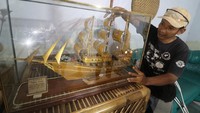 Moch Sobirin memasang kaca pelindung pada karyanya. Miniatur ini dijual secara daring dengan harga Rp350 ribu hingga Rp2,5 juta per buah tergantung ukuran.