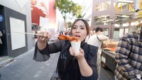 Selain bungeoppang, Maharani juga membeli odeng dari salah satu penjual gerobakan. Odeng itu dimasak dengan bumbu tteokbokki yang pedas manis. Foto: YouTube Maharani Kemala