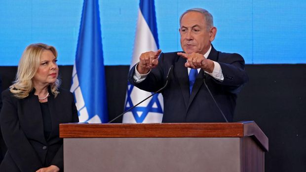 Mantan perdana menteri Israel dan pemimpin partai Likud Benjamin Netanyahu berbicara kepada para pendukung, diapit oleh istrinya Sara, di markas kampanye di Yerusalem pada awal 2 November 2022. (AFP/RONALDO SCHEMIDT)