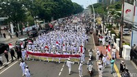 Terlihat barisan laskar berpakaian serba putih berada di depan barisan demonstran.