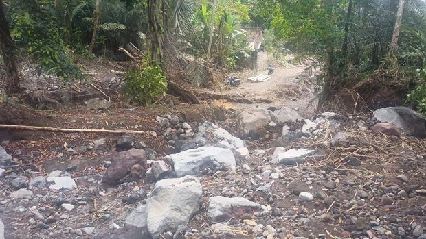 Masyarakat di dekat Pura Penyatur Kaler, Banjar Dinas Abian Tiing Kaje, Desa Jungutan, Karangasem, Bali, harus berjalan kaki karena akses jalan rusak sehingga tidak bisa dilewati kendaraan.