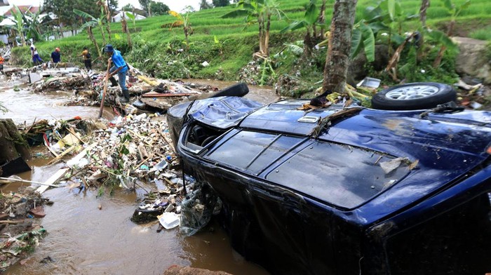 Prajurit TNI AL bersama warga mengevakuasi mobil yang terseret banjir di Kalibaru, Banyuwangi, Jawa Timur, Jumat (4/11/2022). Banjir yang terjadi akibat luapan sungai Iyas pada Kamis (3/11) malam itu mengakibatkan 61 rumah warga rusak berat tersapu banjir, tiga mobil dan 17 hewan ternak hanyut. ANTARA FOTO/Budi Candra Setya/foc.