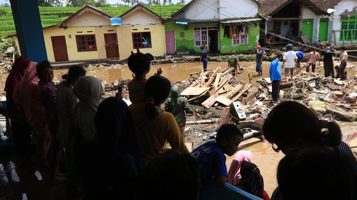 Prajurit TNI AL bersama warga mengevakuasi mobil yang terseret banjir di Kalibaru, Banyuwangi, Jawa Timur, Jumat (4/11/2022). Banjir yang terjadi akibat luapan sungai Iyas pada Kamis (3/11) malam itu mengakibatkan 61 rumah warga rusak berat tersapu banjir, tiga mobil dan 17 hewan ternak hanyut. ANTARA FOTO/Budi Candra Setya/foc.