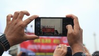 Massa aksi terlihat mengabadikan momen tersebut menggunakan gadget.