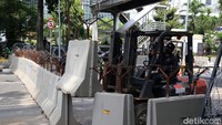 Tampak petugas tengah menata beton untuk menutup jalan.