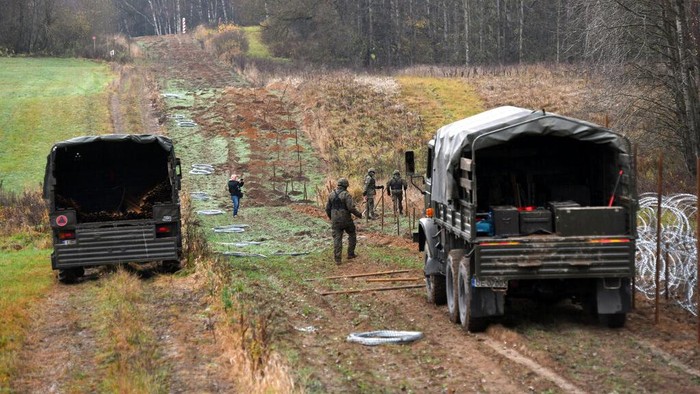 Polish soldiers begin laying a razor wire barrier along Poland’s border with the Russian exclave of Kaliningrad in Wisztyniec, Poland, on Wednesday Nov. 2, 2022. Poland’s government ordered the construction of the barrier after Russia’s aviation authority decided to launch flights from the Middle East and North Africa to Kaliningrad. The Polish government said it was acting to prevent a migration crisis at that border. (AP Photo/Michal Kosc)