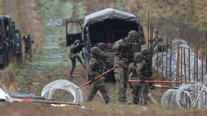 Polish soldiers begin laying a razor wire barrier along Poland’s border with the Russian exclave of Kaliningrad in Wisztyniec, Poland, on Wednesday Nov. 2, 2022. Poland’s government ordered the construction of the barrier after Russia’s aviation authority decided to launch flights from the Middle East and North Africa to Kaliningrad. The Polish government said it was acting to prevent a migration crisis at that border. (AP Photo/Michal Kosc)