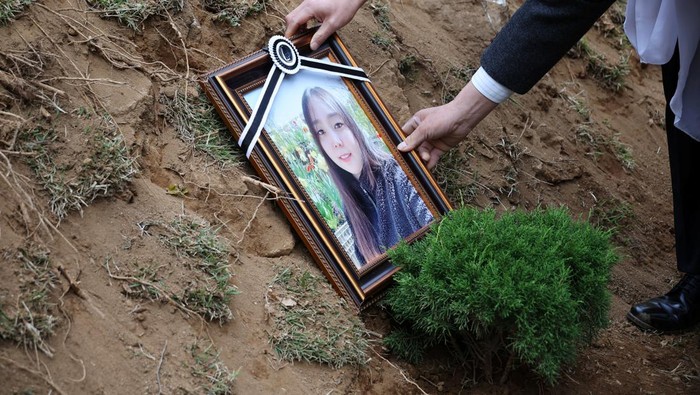 Lee Hyo-sook, 61, mother of Jung Joo-hee, 30, who was one of the victims of a crowd crush that happened during Halloween festivities, grieves next to her daughter's grave in Namyangju, South Korea, November 3, 2022. REUTERS/Kim Hong-Ji