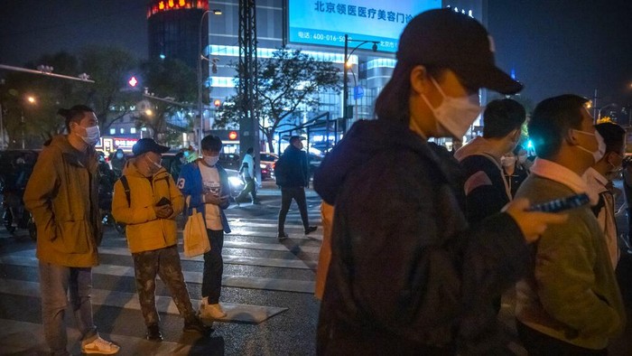 Ramai-ramai Buruh Tinggalkan Zona Industri Zhengzhou Imbas Lockdown Commuters wearing face masks wait at an intersection in Beijing, Wednesday, Nov. 2, 2022. Access to an industrial zone in the central Chinese city of Zhengzhou was suspended Wednesday after the city reported 64 coronavirus cases and workers who assemble Apple Inc. iPhones left their factory in the zone following outbreaks. (AP Photo/Mark Schiefelbein)