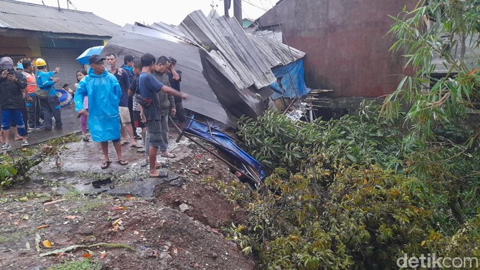 Tebing setinggi 20 meter di Kelurahan Katulampa, Bogor longsor. Sebanyak 3 bangunan rusak dan 4 unit motor tertimbun akibat longsor tersebut. (M Sholihin/detikcom)