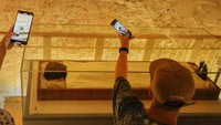 Turis mendokumentasikan mumi Tutankhamun di kamar makamnya di Lembah Para Raja di Luxor, Mesir, Jumat, 4 November 2022.
