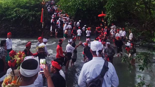 Iring-iringan Ida Bhatara saat upacara melasti harus melewati aliran Sungai Betel setinggi paha orang dewasa, Sabtu (5/11/2022).