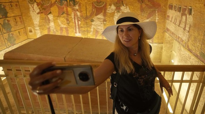 A tourist takes a selfie at the tomb of King Tutankhamun at the Valley of the Kings in Luxor, Egypt, Friday, Nov. 4, 2022. Egypt celebrates the 100-year anniversary of the discovery of Tutankhamun tomb on Nov. 4, 1922 by British archaeologist Howard Carter and his team. (AP Photo/Amr Nabil)