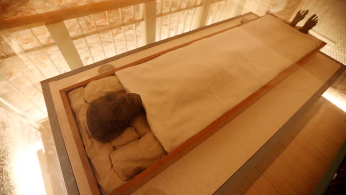 Melihat Mumi Raja Tutankhamun di Lembah Para Raja LUXOR, EGYPT - NOVEMBER 04: The mummy of King Tutankhamun displayed as Egypt marks the 100th anniversary of its discovery, in the Valley of the Kings in Luxor, Egypt, 04 November 2022. Egypt is celebrating the 100th anniversary of the discovery of the 3,000-year-old tomb of the Golden King Tutankhamun that was made on 04 November 1922 by British archaeologist Howard Carter. The tomb of King Tut, also known as KV62, was almost the only discovered tomb not breached by grave robbers in the Valley of the Kings with more than 5,000 pieces, most of them were gold, including his funerary mask, gold sandals, an outer gold-gilded wooden coffin and innermost coffin of solid gold. Tutankhamuns mummy and sarcophagus are still on display in the tomb, while many of the funerary objects discovered were displayed at the Egyptian Museum in Tahrir Square and will be transferred to the new Grand Egyptian Museum in Giza when it opens. (Photo by Fareed Kotb/Anadolu Agency via Getty Images)