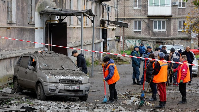 Penembakan di Apartemen Makiivka Ukraina, Seorang Warga Tewas SENSITIVE MATERIAL. THIS IMAGE MAY OFFEND OR DISTURB A local resident walks past the body of a person killed by recent shelling near a damaged block of flats in the course of Russia-Ukraine conflict in Makiivka (Makeyevka), Russian-controlled Ukraine, November 4, 2022. REUTERS/Alexander Ermochenko