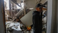 Seorang penduduk setempat berdiri di tengah puing-puing di dalam blok flat yang rusak akibat penembakan selama konflik Rusia-Ukraina di Makiivka (Makeyevka), Ukraina yang dikuasai Rusia, 4 November 2022.