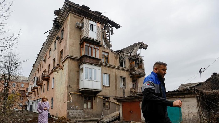 Penembakan di Apartemen Makiivka Ukraina, Seorang Warga Tewas SENSITIVE MATERIAL. THIS IMAGE MAY OFFEND OR DISTURB A local resident walks past the body of a person killed by recent shelling near a damaged block of flats in the course of Russia-Ukraine conflict in Makiivka (Makeyevka), Russian-controlled Ukraine, November 4, 2022. REUTERS/Alexander Ermochenko