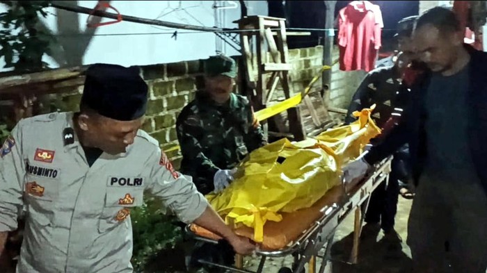 Petugas mengevakuasi jasad korban.