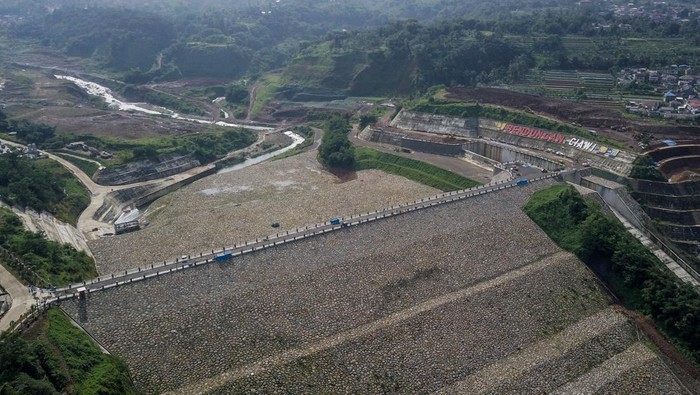 Potret Proyek Penangkal Banjir Jakarta yang Rampung Sebentar Lagi Foto udara proyek pembangunan Bendungan Ciawi di Kabupaten Bogor, Jawa Barat, Sabtu (5/11/2022). Kontraktor proyek pembangunan Bendungan Ciawi PT Brantas Abipraya menargetkan bendungan yang memiliki volume tampung 6.05 juta m3 dan luas genangan 39,40 hektare tersebut akan rampung pada akhir tahun 2022 yang nantinya akan mereduksi banjir sebesar 111,75 meter kubik per detik. ANTARA FOTO/Raisan Al Farisi/YU