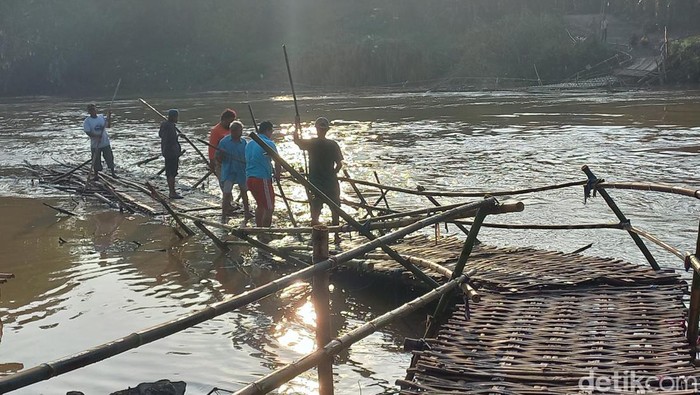 Sejumlah relawan tengah memperbaiki jembatan sesek Ngepung yang putus diterjang arus Bengawan Solo, Sabtu (5/11/2022).