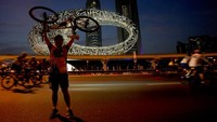 Seorang oeserta mengangkat sepedanya di depan landmark Dubai Museum of the Future. Sheikh Zayed Road merupakan salah satu jalan tersibuk di UEA. Jalanan tersebut akan ditutup untuk lalu lintas pada Minggu pagi saat ribuan pengendara sepeda mengikuti acara Dubai Fitness Challenge.