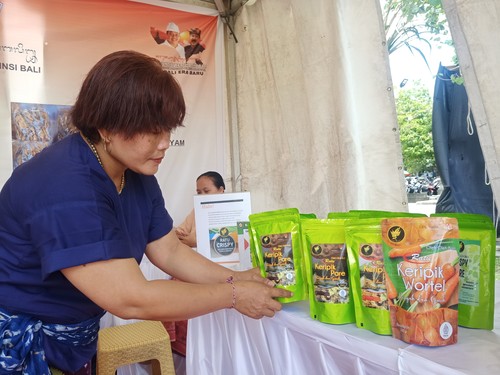 Yuli Setiawati menata produk kripik pare dan wortel di Festival Pangan Lokal Bali 2022 di Lapangan Timur Puputan Margarana Renon, Denpasar, Minggu (6/11/2022).