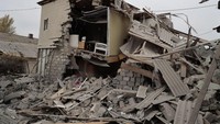 Salah satu rumah warga temboknya hancur sehingga bagian dalamnya terlihat. Foto: Anadolu Agency via Getty Images/Anadolu Agency